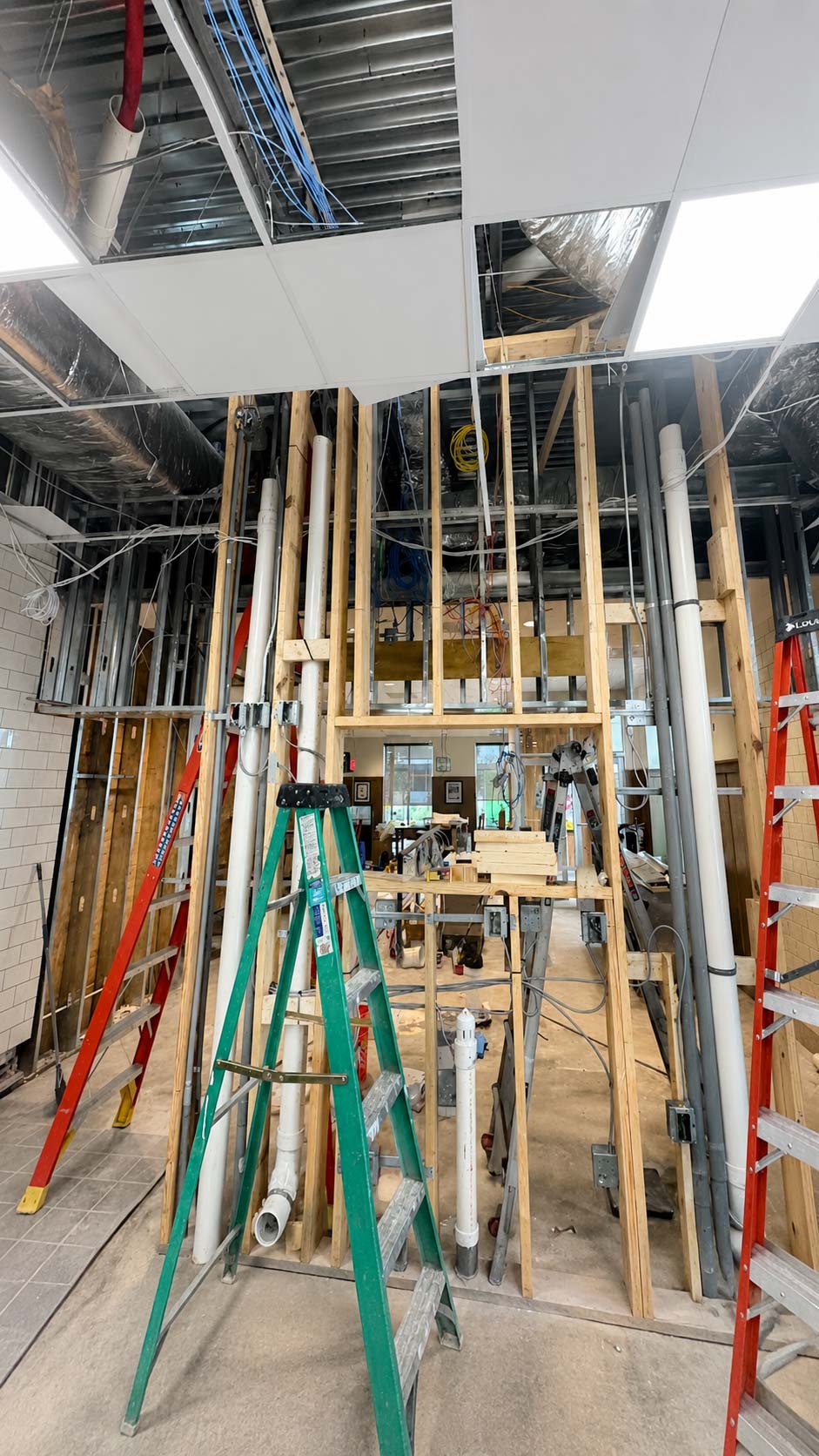 Plumber completing an interior pipe repair inside a finished room