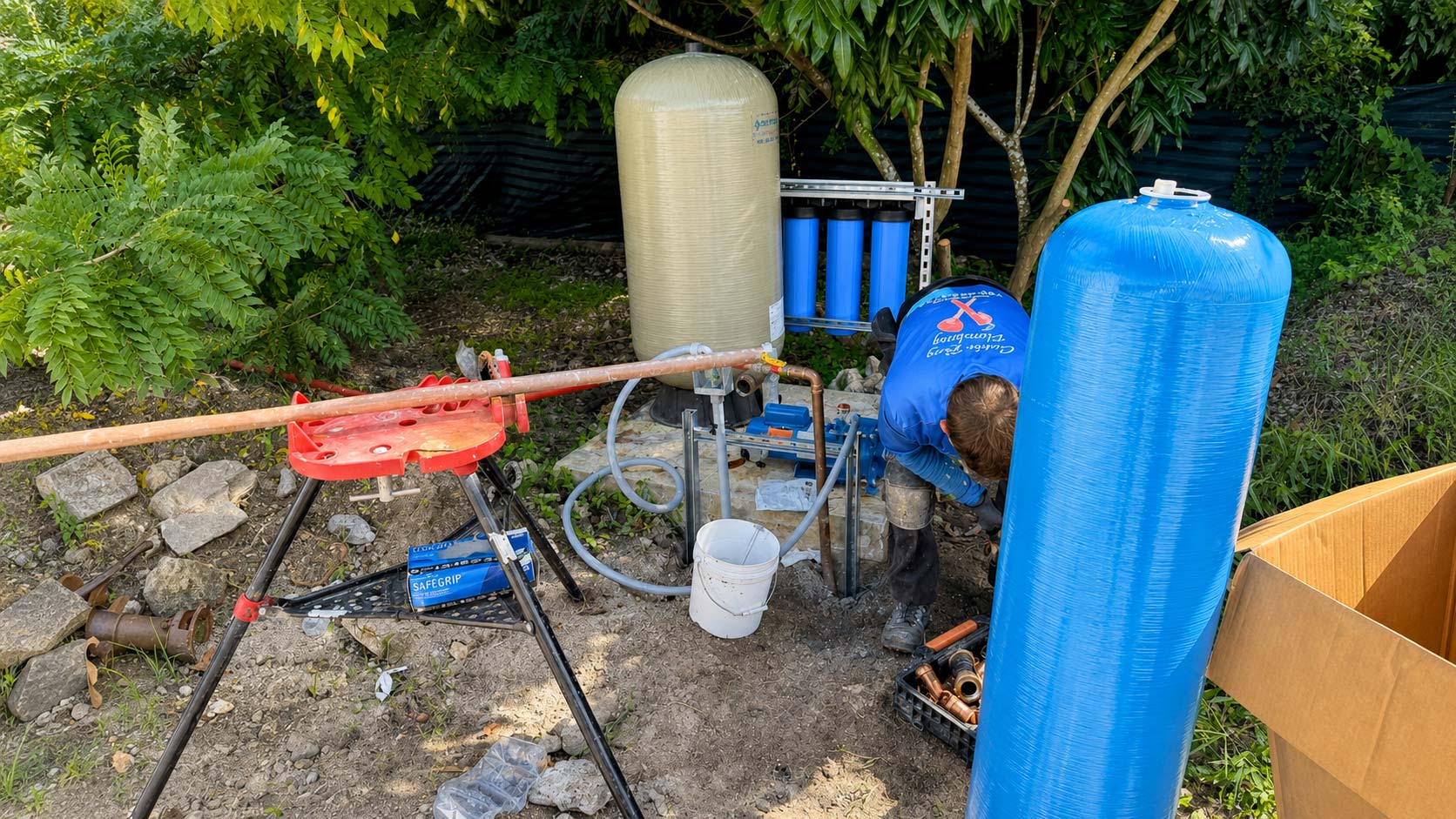 Plumbers connecting new outdoor piping beside a residential property